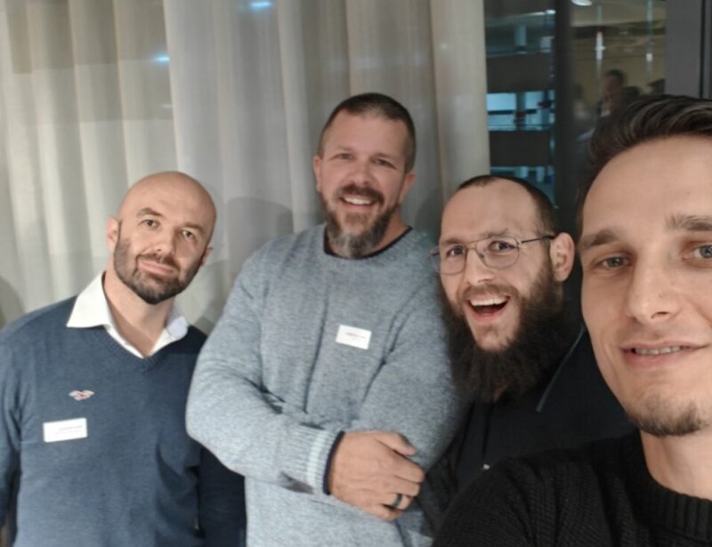 Four people posing together indoors